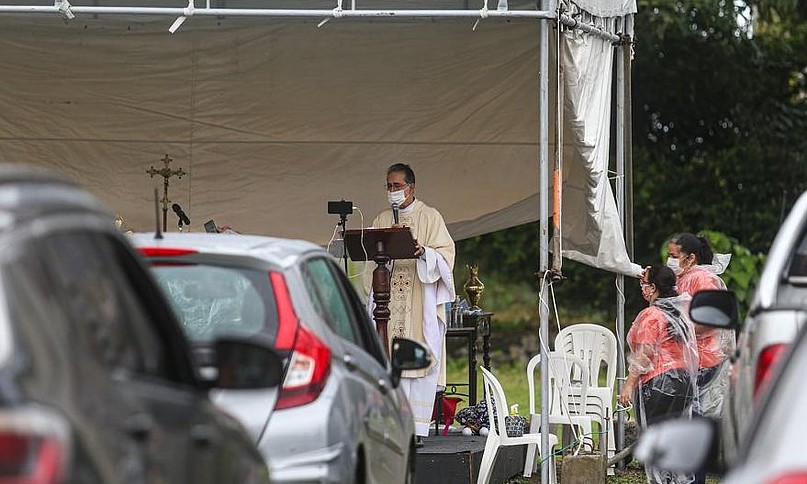 ‘Drive-in da fé’: padres católicos celebram missa e ministram sacramento – veja