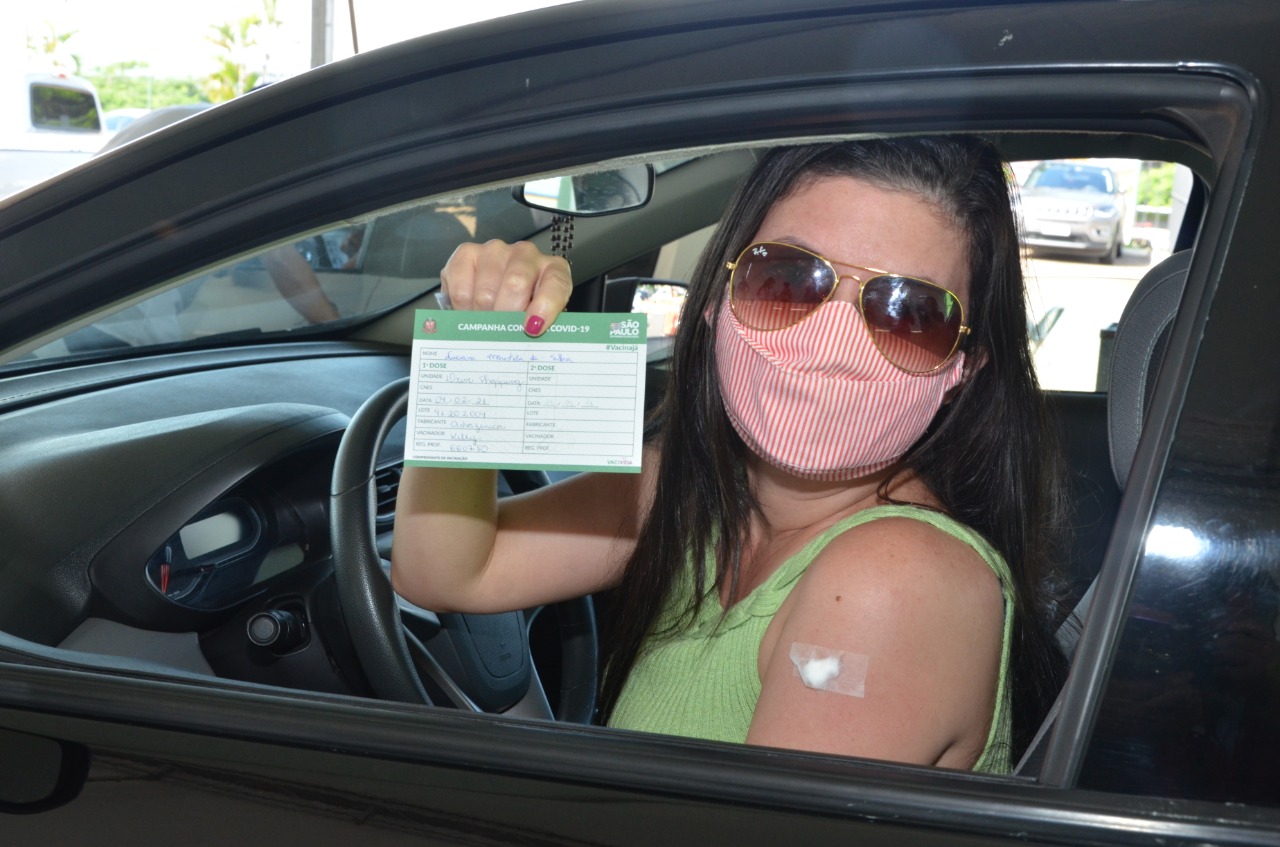 Profissional imunizada mostra seu comprovante de vacinação