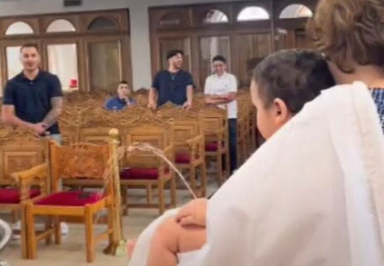 Menino faz xixi durante batizado e padre mostra agilidade para não ser molhado
